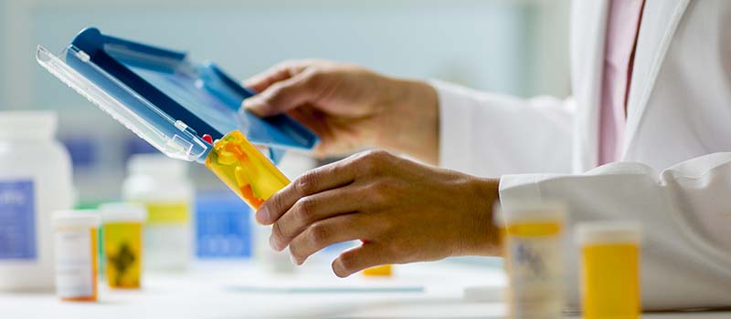 Doctor placing prescription dosage in bottle